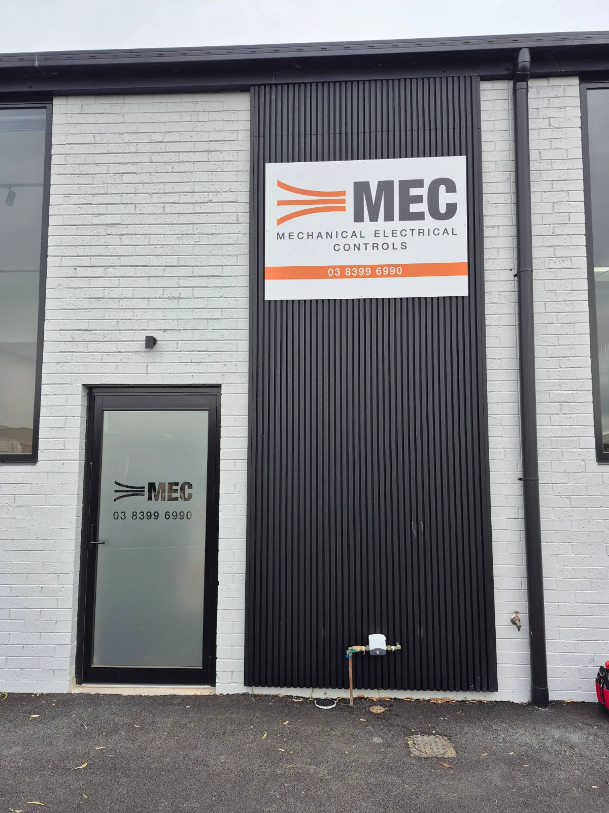 Completed MEC building signage with ACM panel and branded entry door frosting