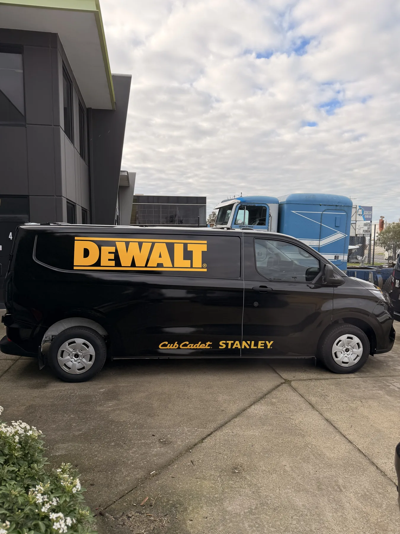 Side view of a gloss black DEWALT commercial van completed by BrandNation Group